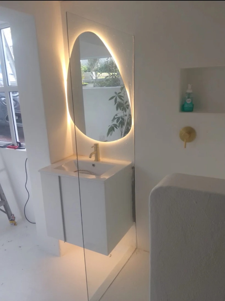 Backlit mirror and vanity lighting installed in a bathroom