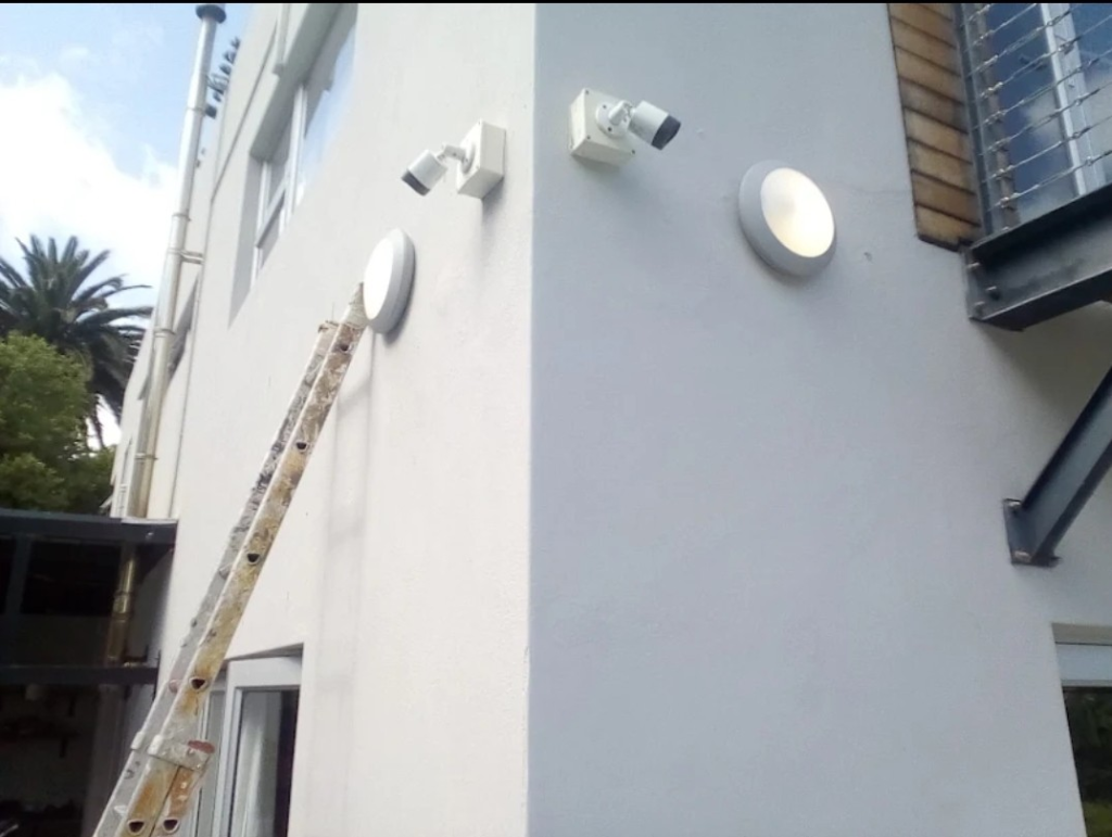 Outdoor security lighting and camera points installed on a wall