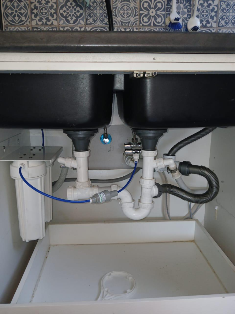 Under-sink plumbing with traps and connectors